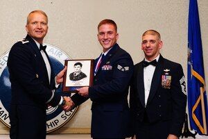 Col. Darren Hartford, 437th Airlift Wing commander, and Chief Master Sgt. Shawn Hughes, 437th Airlift Wing command chief, present Senior Airman David Shelby  , 437th Aircraft Maintenance Squadron crew chief, the John Levitow Award during the Airman Leadership School Class 13-F graduation ceremony Aug. 29, 2013, at JB Charleston - Air Base, S.C. The Levitow Award is awarded for a student's exemplary demonstration of excellence, both as a leader and scholar. (U.S. Air Force photo/ Airman 1st Class Chacarra Neal)