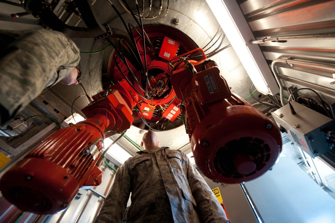 Staff Sgt. Robert Banker and Senior Airman Andrew Ross, 28th Communications Squadron ground radar maintenance technicians, inspect antenna drive motors at the radar tower center in Box Elder, S.D., Aug. 27, 2013. The drive motors rotate the antenna to ensure Ellsworth Air Force Base has situational awareness of air traffic for 15 civilian satellite airports, two Air Force bases, and more than 22,000 square miles of airspace spanning five states. (U.S. Air Force photo by Airman 1st Class Zachary Hada/Released)