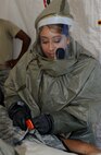 Airman 1st Class Leslie Coria, 28th Medical Operations Squadron dental technician, simulates cutting through a patient’s clothing during an in place patient decontamination training exercise at Ellsworth Air Force Base, S.D., Aug. 27, 2013. The decontamination process consists of thoroughly washing and rinsing victims before they are taken into the clinic for treatment. (U.S. Air Force photo by Airman 1st Class Anania Tekurio/Released)