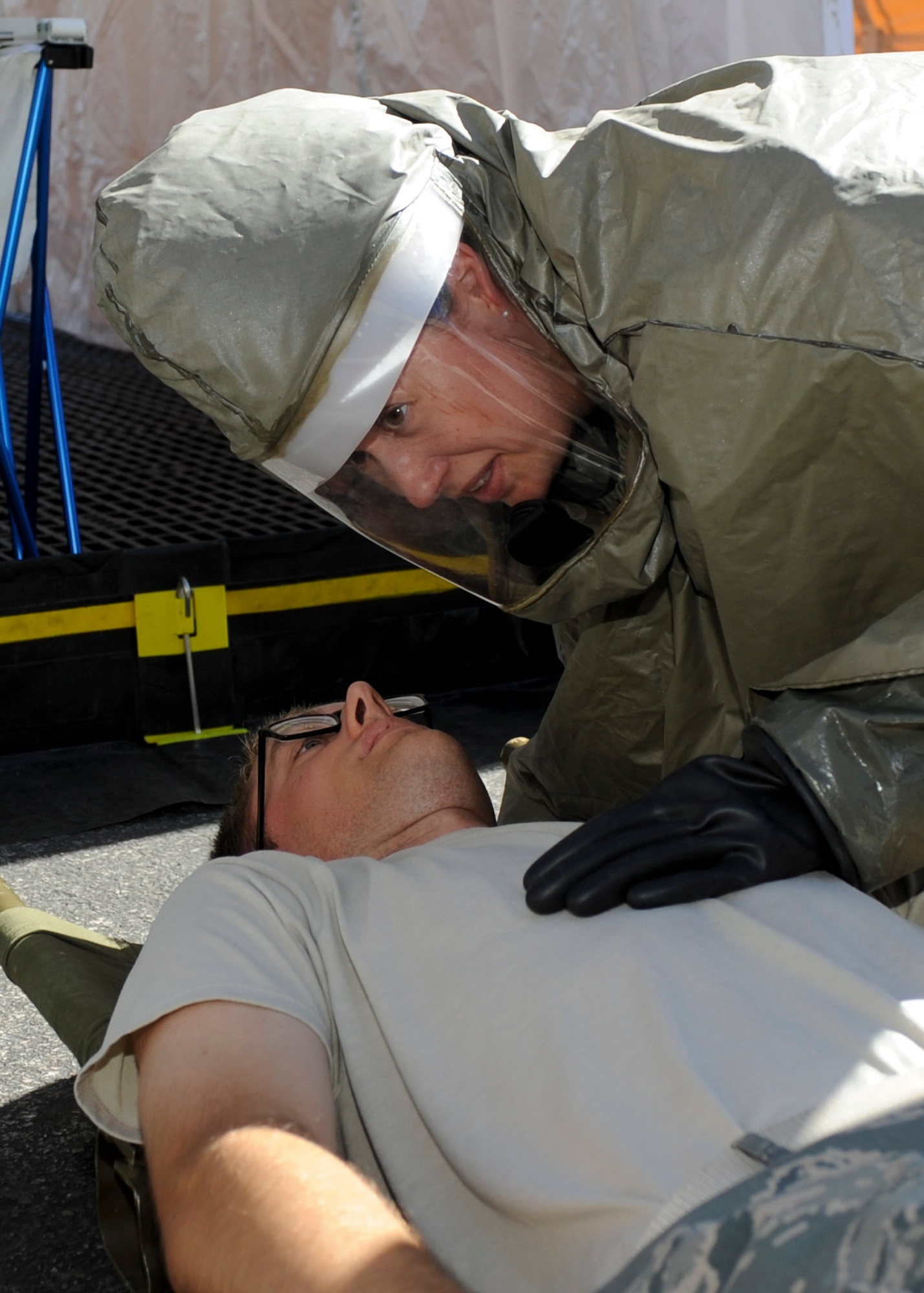 Staff Sgt. Taylor Johnson, 28th Medical Operations Squadron dental technician, checks vital signs of Capt. Cory Peterson, 28th MDOS dentist, during an in place patient decontamination training exercise at Ellsworth Air Force Base, S.D., Aug. 27, 2013. IPPD training is designed to teach Air Force first responders life-saving techniques, how to initiate field treatments and hazardous materials decontamination techniques. (U.S. Air Force photo by Airman 1st Class Anania Tekurio/Released)