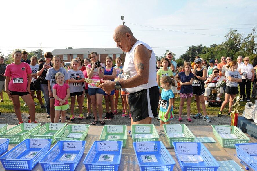 Retired U.S. Air Force Master Sgt. Joe Christian hands out trophies following the Flatlander 5K road race in Lakeland, Ga., Aug. 31, 2013. Christian first ran the Flatlander 5K road race in 1978, and his most recent finish marked his 1,000th competitive race. (U.S. Air Force photo by Master Sgt. Sonny Cohrs/Released)