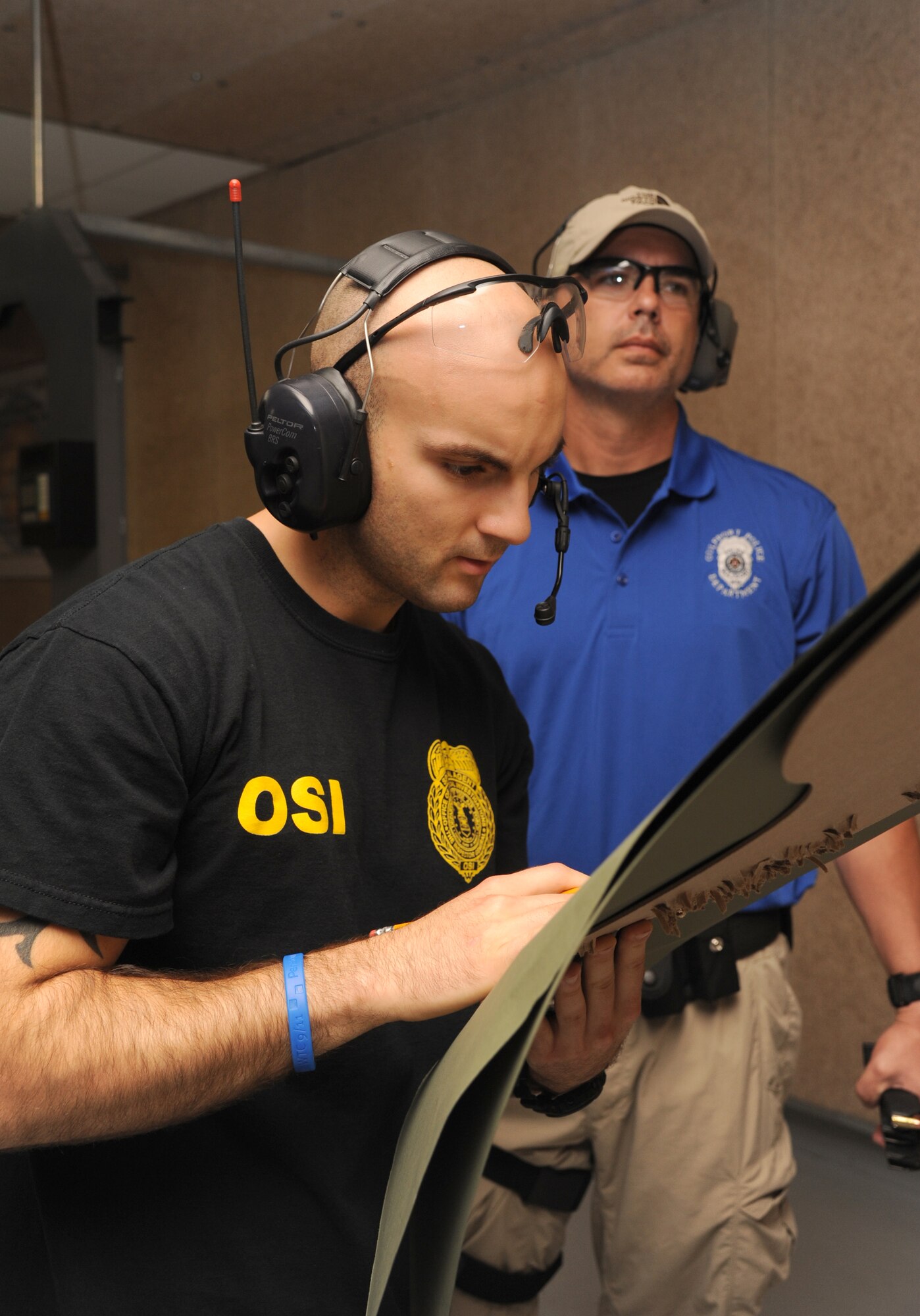 Special Agent Albert Carrasco, U.S. Air Force Office of Special Investigations, counts the hits on a target shot by Sergeant Paul Podlin, Gulfport Police Department, during the second annual Air Force Office of Special Investigations and the 81st Security Forces Squadron’s pistol shoot-off competition Aug. 30, 2013, at the indoor firing range, Keesler Air Force Base, Miss.  Gulfport placed first among the nine five-man teams from local law enforcement agencies that competed in the event.  (U.S. Air Force photo by Kemberly Groue)