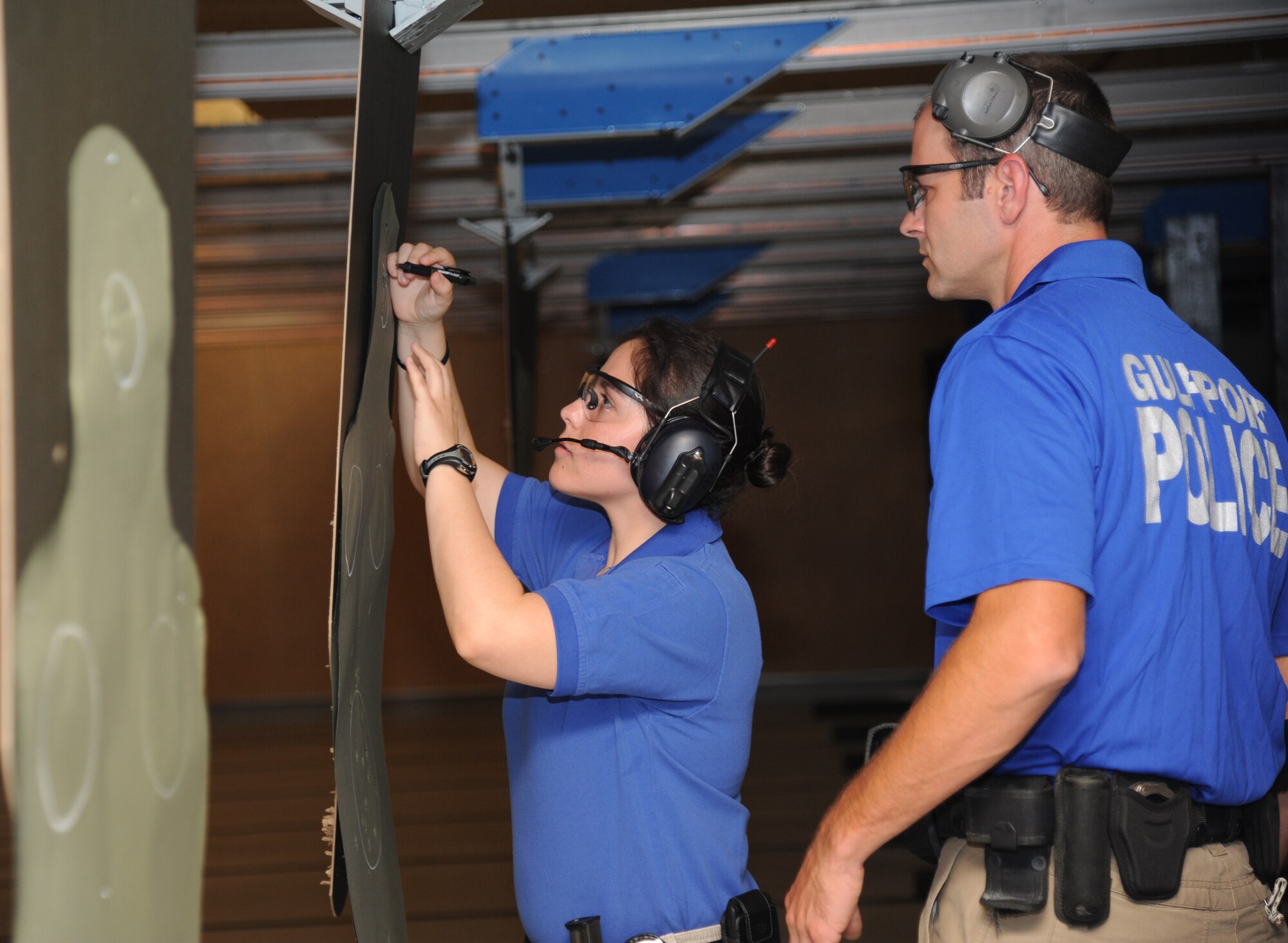 Special Agent Cristina Rangel, U.S. Air Force Office of Special Investigations, counts the hits on a target shot by Detective Sammy Jewell, Gulfport Police Department, during the second annual Air Force Office of Special Investigations and the 81st Security Forces Squadron’s pistol shoot-off competition Aug. 30, 2013, at the indoor firing range, Keesler Air Force Base, Miss.  Gulfport placed first among the nine five-man teams from local law enforcement agencies that competed in the event.  (U.S. Air Force photo by Kemberly Groue)