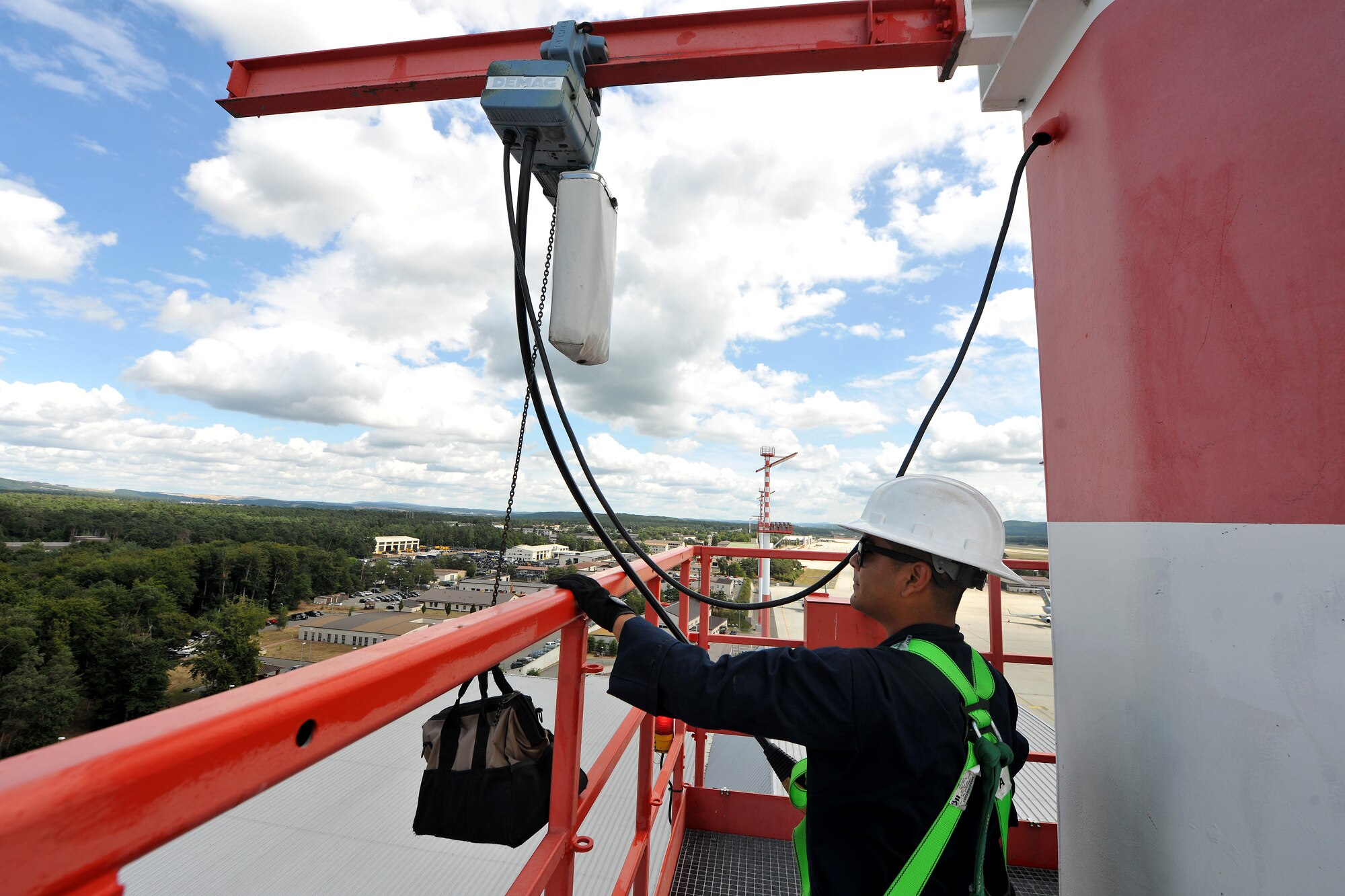 Airman 1st Class Kyle Rivera, 786th Civil Engineer Squadron electrical systems section technician, uses a crane to pull-up extra equipment to the ramp light platform, Aug. 19, 2013, Ramstein Air Base, Germany.  The ramp lights consist of 25, 2000-watt light bulbs and are maintained every quarter to ensure all bulbs are in working condition.  (U.S. Air Force photo/Senior Airman Chris Willis)