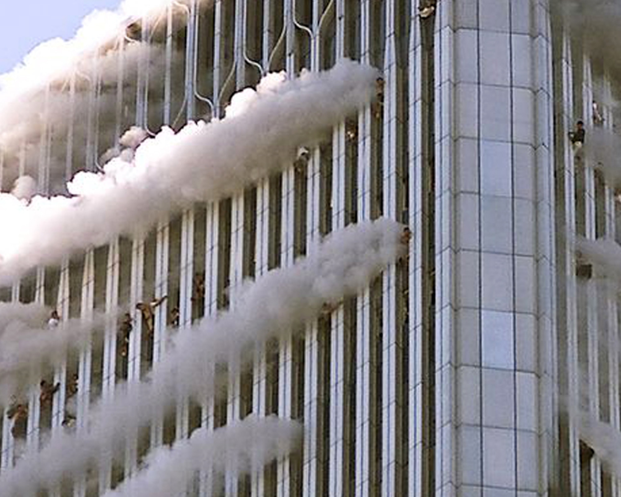 Driven out of the building by fires and scorching temperatures, people near the top of the World Trade Center’s North Tower hang from windows as high as 1,300-feet above the streets of New York City, Sept. 11, 2001. Hijackers crashed American Airlines Flight 11 into floors 93 through 99 of the North Tower. (Getty Images photo by Jose Jimenez/Released)