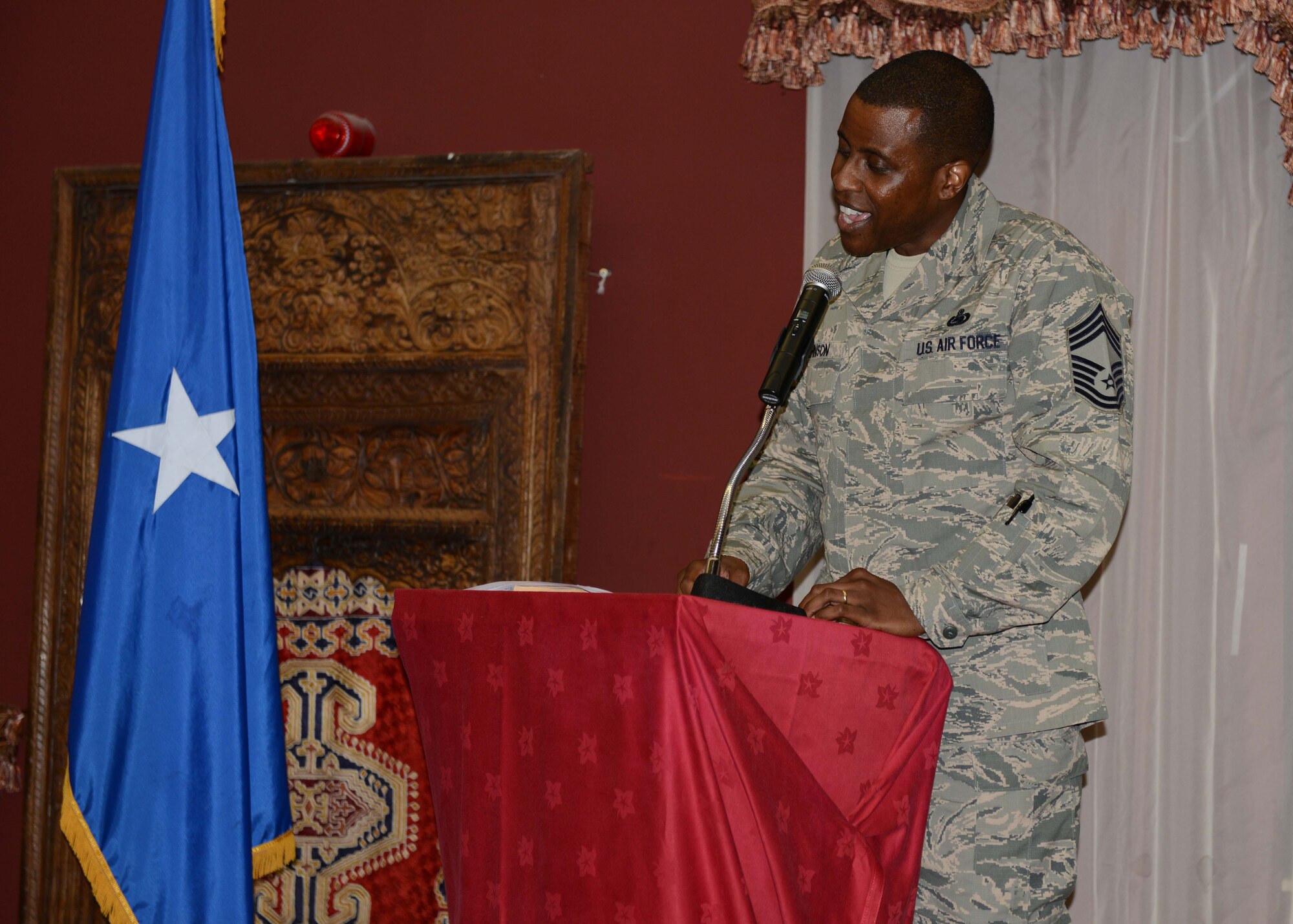 Chief Master Sgt. Marcus Johnson addresses a Grand Slam audience during a Senior NCO Induction Ceremony at the 379th Air Expeditionary Wing in Southwest Asia, Aug. 30, 2013. Johnson was the keynote speaker for the event and offered words of wisdom from his 20 years of enlisted experience to the up-and-coming senior leaders. Johnson is the 379th Expeditionary Logistics Readiness Squadron chief enlisted manager and hails from Paducah, Ky. (U.S. Air Force photo/Senior Airman Bahja J. Jones) 
