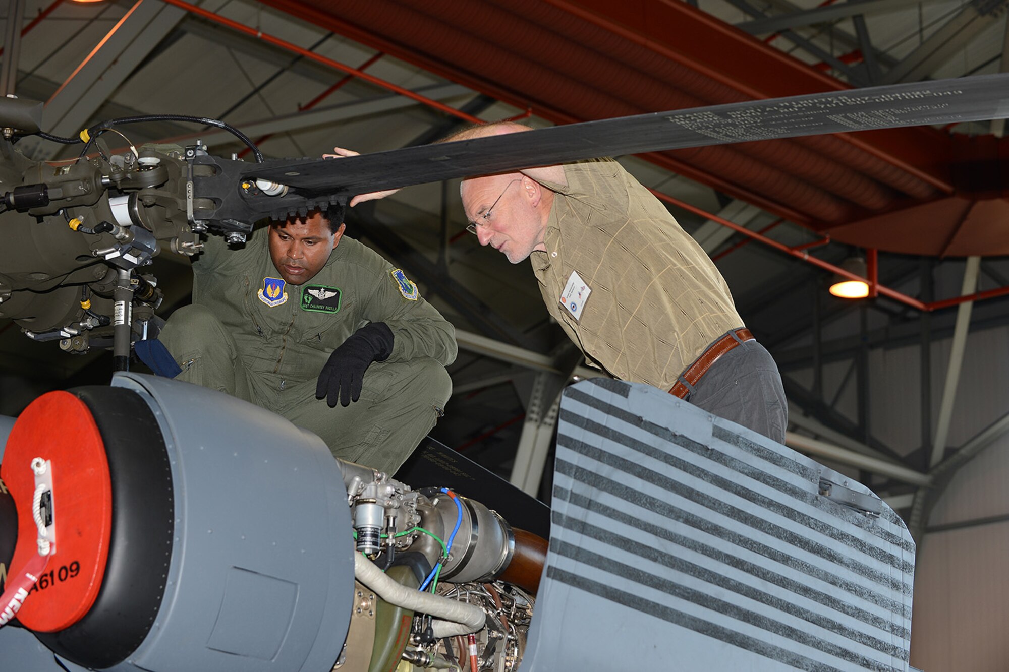Staff Sgt. Chauncey Padilla, 56th Rescue Squadron aerial gunner, teaches Adam Wankowski, Royal Air Force Flying Clubs Association member of RAF Benson, the operations of an HH-60 Pave Hawk at RAF Lakenheath, England, Aug. 26, 2013. RAFFCA members integrated with Liberty Wing aircrew by participating in a safety discussion,  base tour,  birds-of-prey demonstration and static displays of an F-15C Eagle, HH-60 Pave Hawk and munitions. (U.S. Air Force photo by Airman 1st Class Trevor T. McBride/Released)