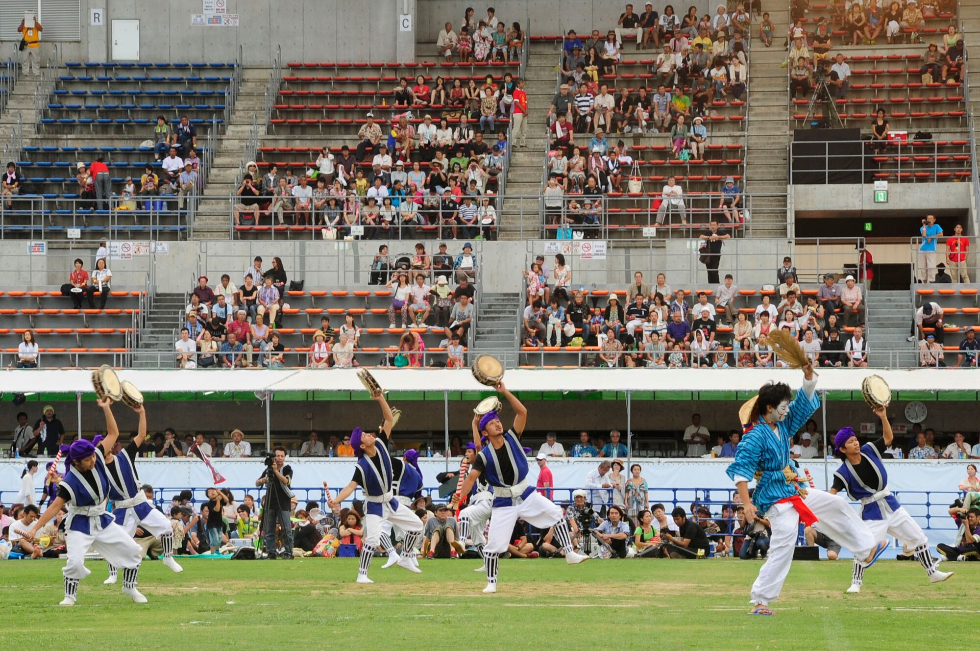 A Taiko drum group and chondaras perform for the crowd during the 58th Okinawa Zento Eisa Festival in Koza Athletic Park Aug. 31, 2013. Different youth groups performed for the crowd during the second day of the three-day island-wide event.  (U.S. Air Force photo by Staff Sgt. Darnell T. Cannady)