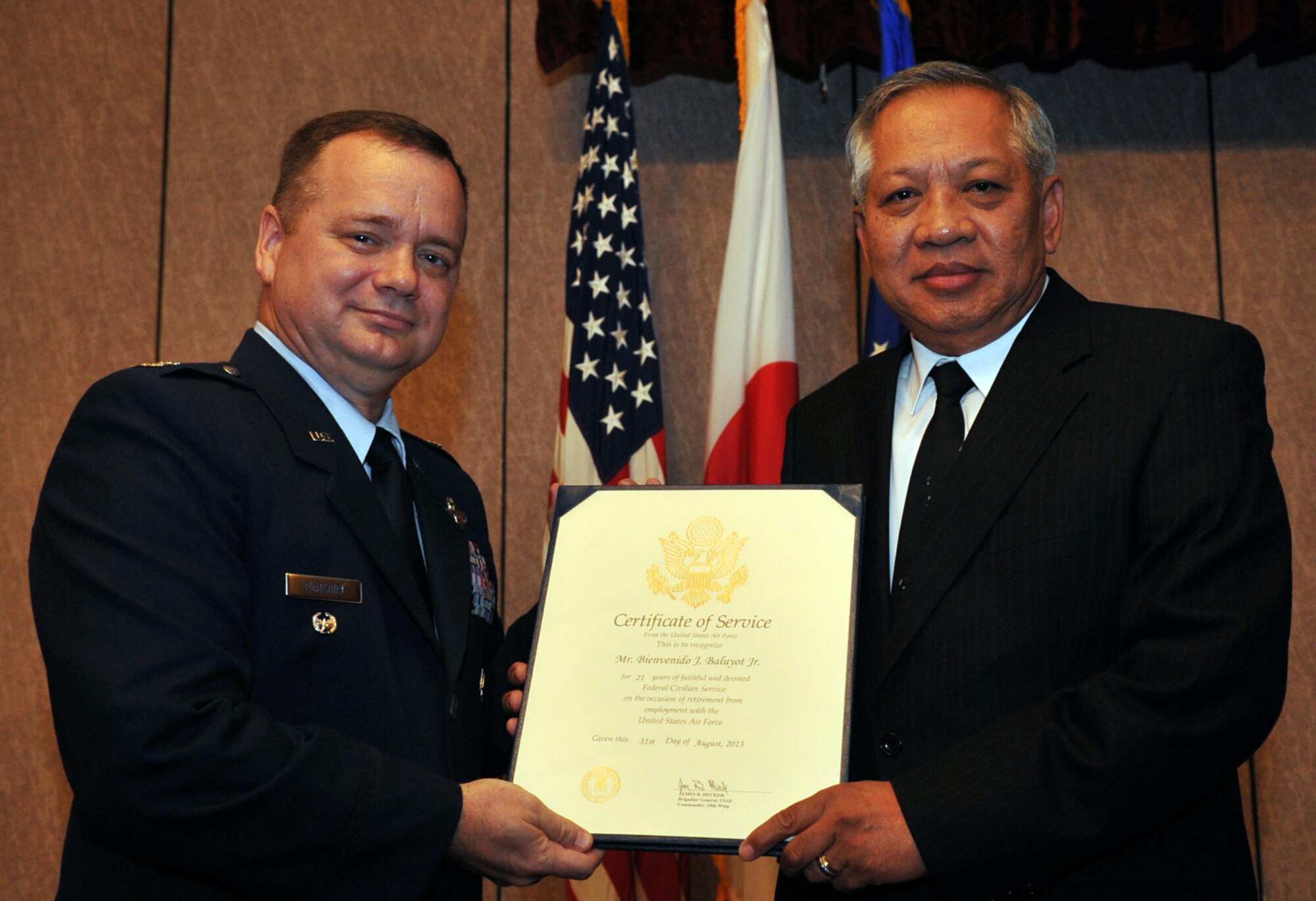 U.S. Air Force Col. Brian McDaniel, 18th Wing vice commander, awards Bienvenido Baluyot a certificate of service during Baluyot’s retirement ceremony at the NCO Club on Kadena Air Base, Japan, Aug. 29, 2013. Baluyot was born in Manila, Republic of the Philippines, and served 23 years active duty Air Force. He retired in the grade of senior master sergeant, Apr. 1, 1992, at Robins Air Force Base, Ga., where he continued service as a government civilian. Baluyot served his country for more than 44 years. (U.S. Air Force photo by Naoto Anazawa)