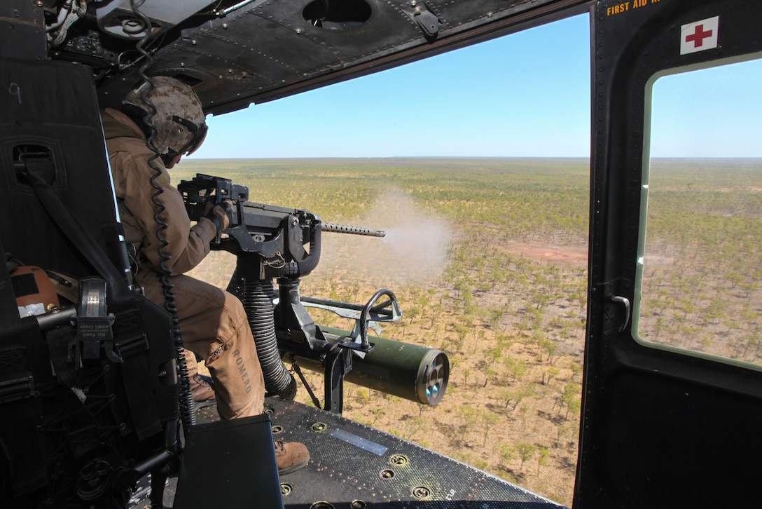 U.S. Marine Corps Lance Cpl. Jon D. Romero fires a .50 caliber GAU-21 machine gun from a UH-1Y Venom helicopter during exercise Koolendong 13 in Australia, Sept. 2, 2013. Romero, a crew chief, is assigned to Marine Medium Tiltrotor Squadron 265 Reinforced, 31st Marine Expeditionary Unit. Three Venom helicopters and four MV-22 Osprey aircraft are being used in the exercise.