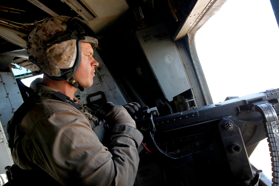 U.S. Marine Corps Cpl. Andrew J. Fitzgerald provides aerial security with a GAU-21 .50-caliber machine gun inside a CH-53E Super Stallion helicopter over Helmand province, Afghanistan, Aug. 22, 2013. Fitzgerald, a crew chief, is assigned to Marine Heavy Helicopter Squadron 462.
