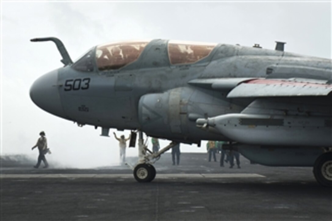 A U.S. Navy EA-6B Prowler is directed to the catapult on the flight deck of the aircraft carrier USS Nimitz (CVN 68) as the ship conducts flight operations in the Gulf of Oman on Aug. 28, 2013.  The Nimitz Carrier Strike Group is deployed to the 5th Fleet area of responsibility to conduct maritime security operations and theater security cooperation efforts.  The Prowler is assigned to Electronic Attack Squadron 142.  
