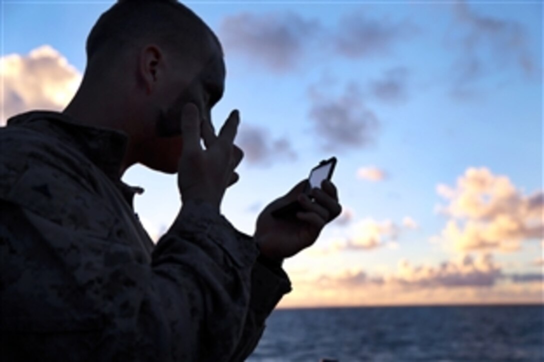 Marine Corps Lance Cpl. Ryne Larson applies camouflage paint to his face before conducting an amphibious training raid for Tropic Thunder, an exercise on Marine Corps Base Hawaii, Kaneohe Bay, Aug. 30, 2013. Larson, a team leader, is assigned to Bravo Company, Battalion Landing Team, 1st Battalion, 4th Marine Regiment, 13th Marine Expeditionary Unit.