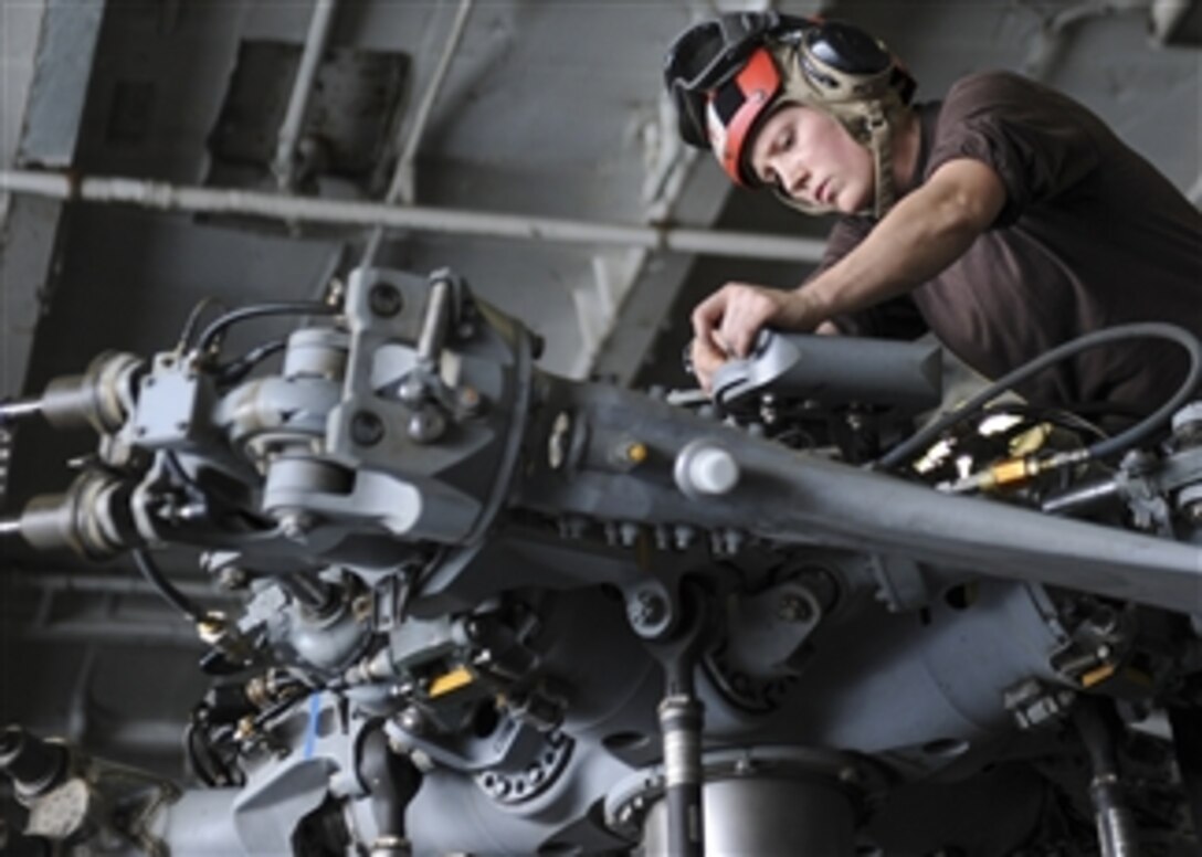U.S. Navy Airman Lauren Houk conducts daily inspections on an MH-60R Sea Hawk helicopter in the hangar bay of the aircraft carrier USS Nimitz (CVN 68) as the ship operates in the Gulf of Oman on Aug. 26, 2013.  The Nimitz Carrier Strike Group is deployed to the 5th Fleet area of responsibility to conduct maritime security operations and theater security cooperation efforts.  DoD photo by Petty Officer 3rd Class Chris Bartlett, U.S. Navy.  (Released)