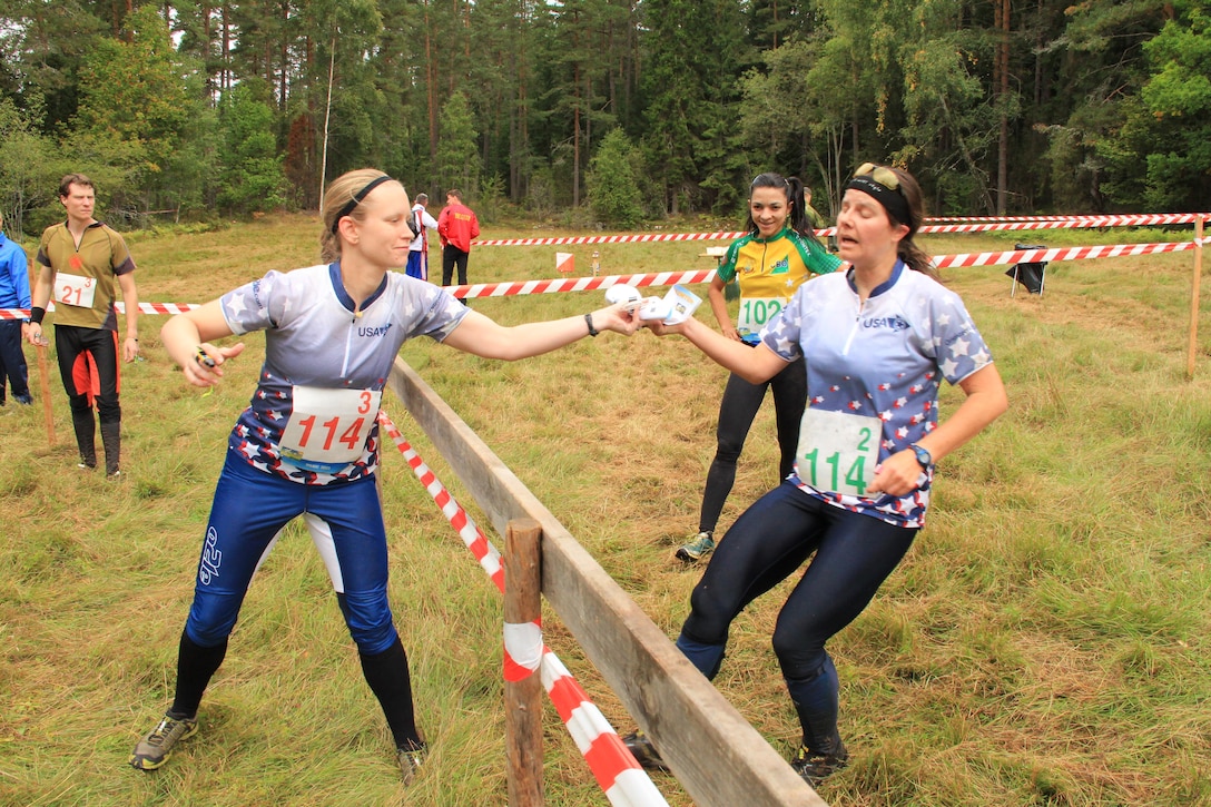 Maj Maiya Anderson (USAF) (left) hands off to LT Virginia Debons (Navy) in the Women's relay at the 2013 CISM World Orienteering Military Championship hosted by the Swedish Armed Forces in Eksjo, Sweden from 26 August to 1 September.