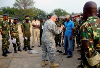 Master Sgt. Derek Gill demonstrates proper use of portable scales with the assistance of an interpreter. Gill and fellow Georgia Army National Guardsman Staff Sgt. Samuel Perez trained more than 30 Burundi soldiers during a two-week Africa Deployment Assistance Partnership Team training known as ADAPT.