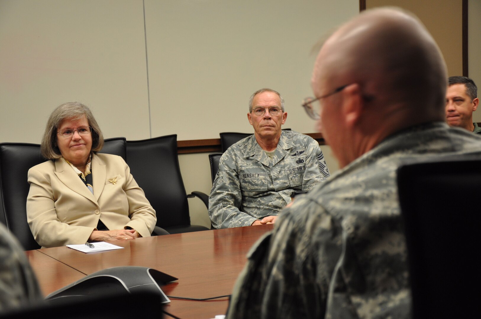 Holly Petraeus, the assistant director at the Consumer Financial Protection Bureau for the Office of Service Member Affairs, sits next to Command Chief Doug Hensala, state command chief for the Wyoming Air National Guard, as they both listen to Maj. Gen. Luke Reiner, adjutant general for Wyoming, during a discussion on potential financial pitfalls for troops, Oct. 4, 2012.