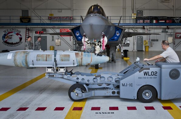 Tech Sgt. Russ Fontaine maneuvers the guided-bomb-unit-31 into position to be loaded onto an F-35A Lightning II Aug. 27, 2013, at Eglin Air Force Base, Fla. This marked the first time Airmen have loaded weapons onto the new joint strike fighter here. Each step and procedure was analyzed to ensure it was correct or needed to be changed. The weapons load procedures perfected by the MXG Airmen will be taught to maintenance students in the future. Fontaine is assigned to the 33rd Maintenance Group. (U.S. Air Force photo/Samuel King Jr.)