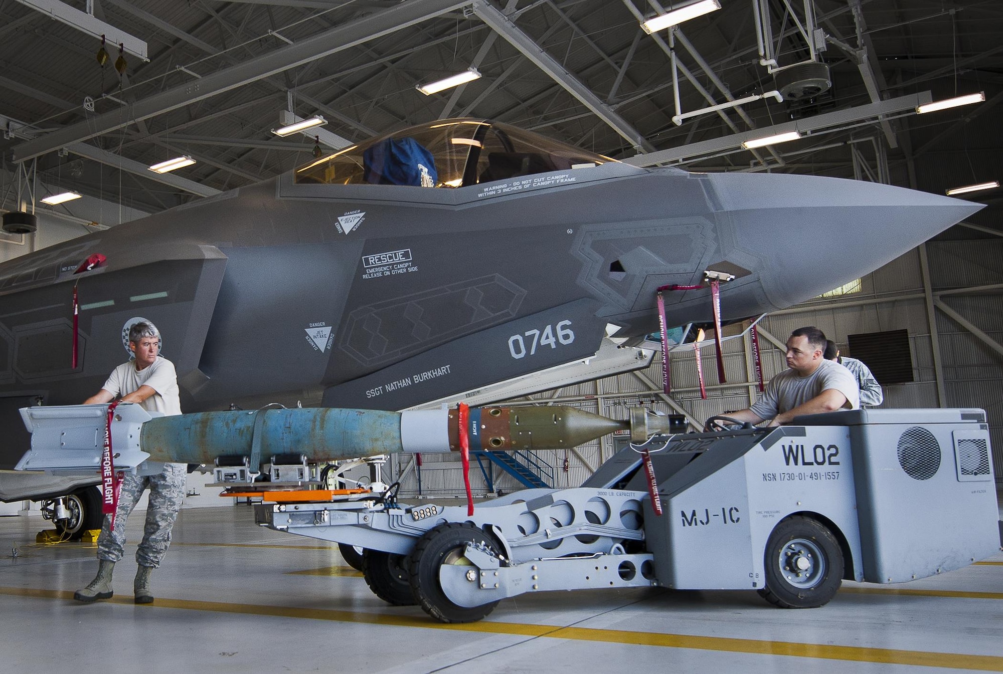 Master Sgt. Karen Griffin maneuvers the guided-bomb-unit-12 into position to be loaded onto an F-35A Lightning II Aug. 27, 2013, at Eglin Air Force Base, Fla. This marked the first time Airmen have loaded weapons onto the new joint strike fighter here. Each step and procedure was analyzed to ensure it was correct or needed to be changed. The weapons load procedures perfected by the 33rd Maintenance Group Airmen will be taught to maintenance students in the future. Griffin is assigned to the 33rd MXG. (U.S. Air Force photo/Samuel King Jr.)