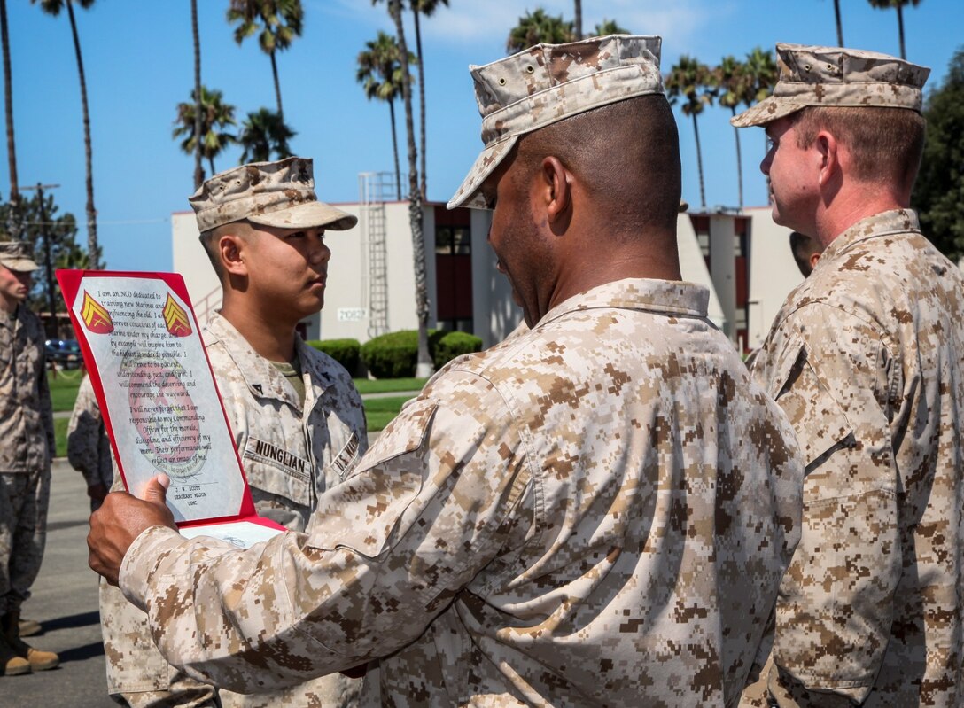 Lance Cpl. Amos M. Nunglian, field radio operator, Command Element, 15th Marine Expeditionary Unit, stands at the position of attention while Sgt. Maj. John W. Scott, sergeant major, 15th MEU, reads his promotion warrant to corporal during a promotion ceremony held on the Camp Del Mar Parade Deck aboard Camp Pendleton, Calif., Sept. 3. Nunglian, 21, is from Rockville, Md. (U.S. Marine Corps photo by Cpl. Emmanuel Ramos/Released)