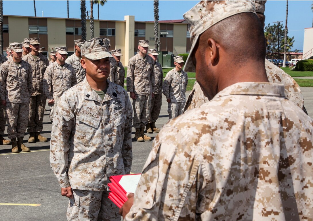 Petty Officer Second Class Wendell Tabios, Fleet Marine Force hospital corpsman, Command Element, 15th Marine Expeditionary Unit, stands at the position of attention while Sgt. Maj. John W. Scott, sergeant major, 15th MEU, reads his promotion warrant to petty officer first class during a promotion ceremony held on the Camp Del Mar Parade Deck aboard Camp Pendleton, Calif., Sept. 3. Tabios, 36, is from Fallbrook, Calif. (U.S. Marine Corps photo by Cpl. Emmanuel Ramos/Released)