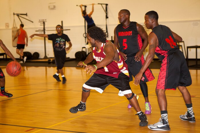 Basketball players battle during the 3-on-3 tournament at Stone Bay Gymnasium aboard Marine Corps Base Camp Lejeune, Aug 22. In the championship game, Marine Corps Community Services employee team, the Three Musketeers, emerged victorious.