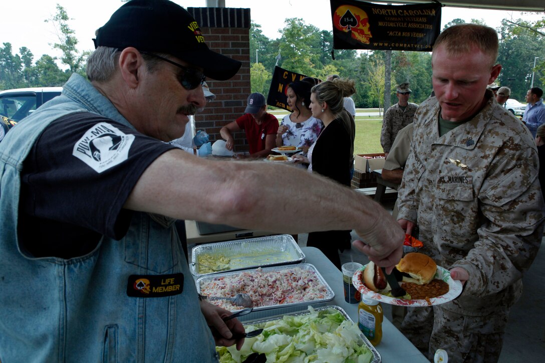 Sgt. John A. Blansett Jr., a Wounded Warrior Battalion-East Marine, receives food from a Combat Veterans Motorcycle Association Chapter 15-4 member during the chapter’s Fall Wounded Warrior Pig Pickin’ Cookout behind the WWBn barracks, Aug. 29. Some of the CVMA members who helped organize the cookout rode their motorcycles from Fayetteville, N.C., to meet and share stories with the service members.

