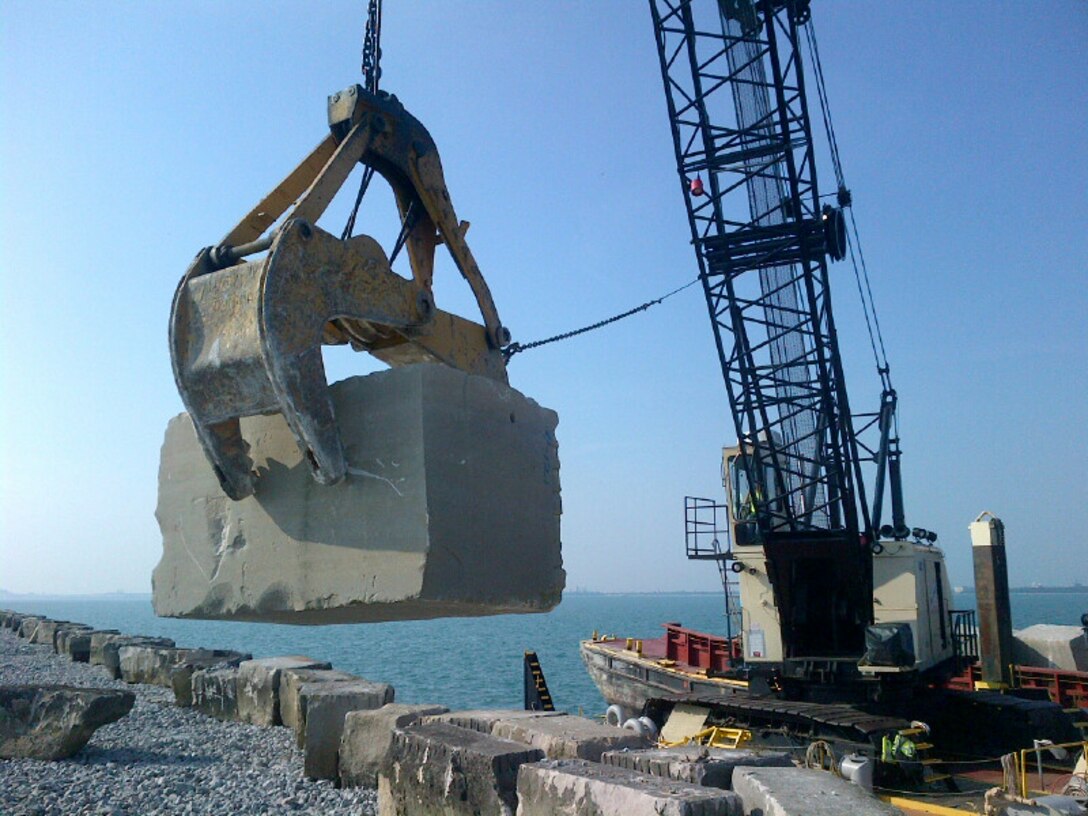 The Manitowoc Crane Barge lays down a cut stone, weighing up to nine tons, at the Calumet Harbor breakwall during summer maintenance.