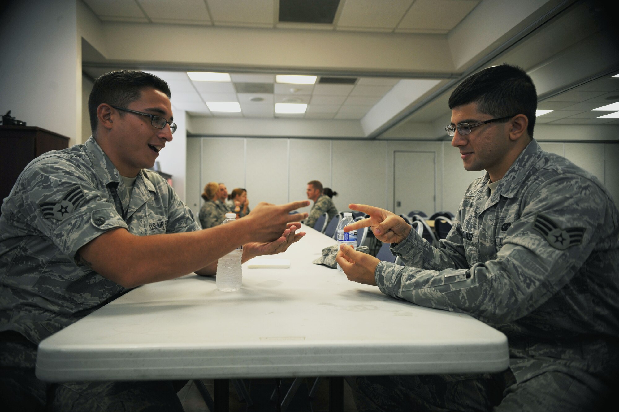U.S. Air Force Senior Airman Joshua Cedeno and Senior Airman Andrew Longaker, 355th Comptroller Squadron financial management flight technicians, play rock, paper, scissors during a squadron burger burn at Davis-Monthan Air Force Base, Ariz., Aug. 29, 2013. Relaxed interaction with coworkers is one way Airmen can strengthen the social pillar of their Comprehensive Airman Fitness. (U.S. Air Force photo by Senior Airman Timothy Moore).