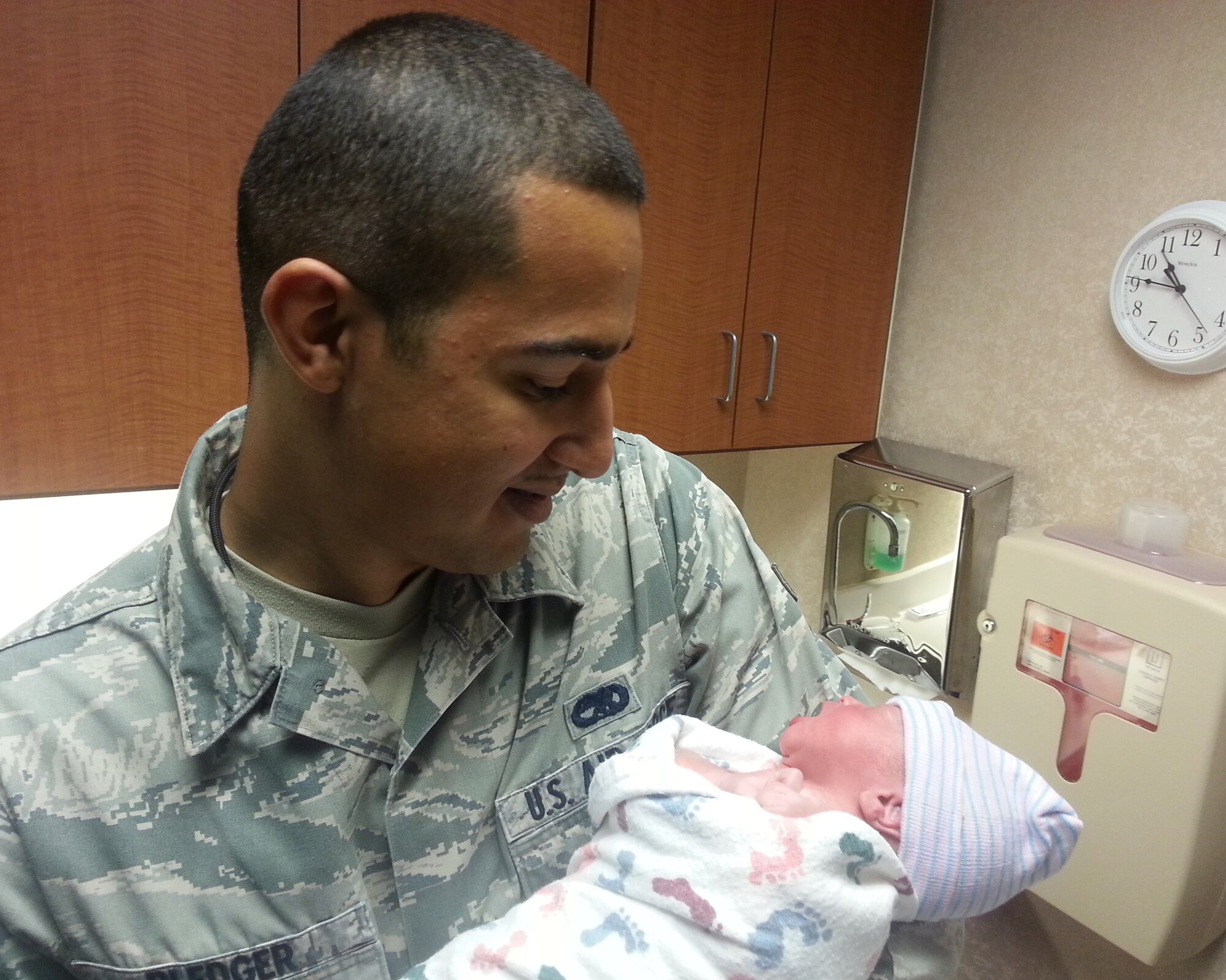 Airman 1st Class Timothy Pledger, 20th Aircraft Maintenance Unit electronic warfare journeyman, holds his daughter, Zoey, hours after delivering her himself Aug. 30, 2013. Pledger's flight to deploy to Guam had been delayed so he went home to be with his pregnant wife. Not long after he came home, she went into labor. In less than an hour, Pledger and his wife welcomed in their new baby girl, Zoey, into the family. (Courtesy photo)