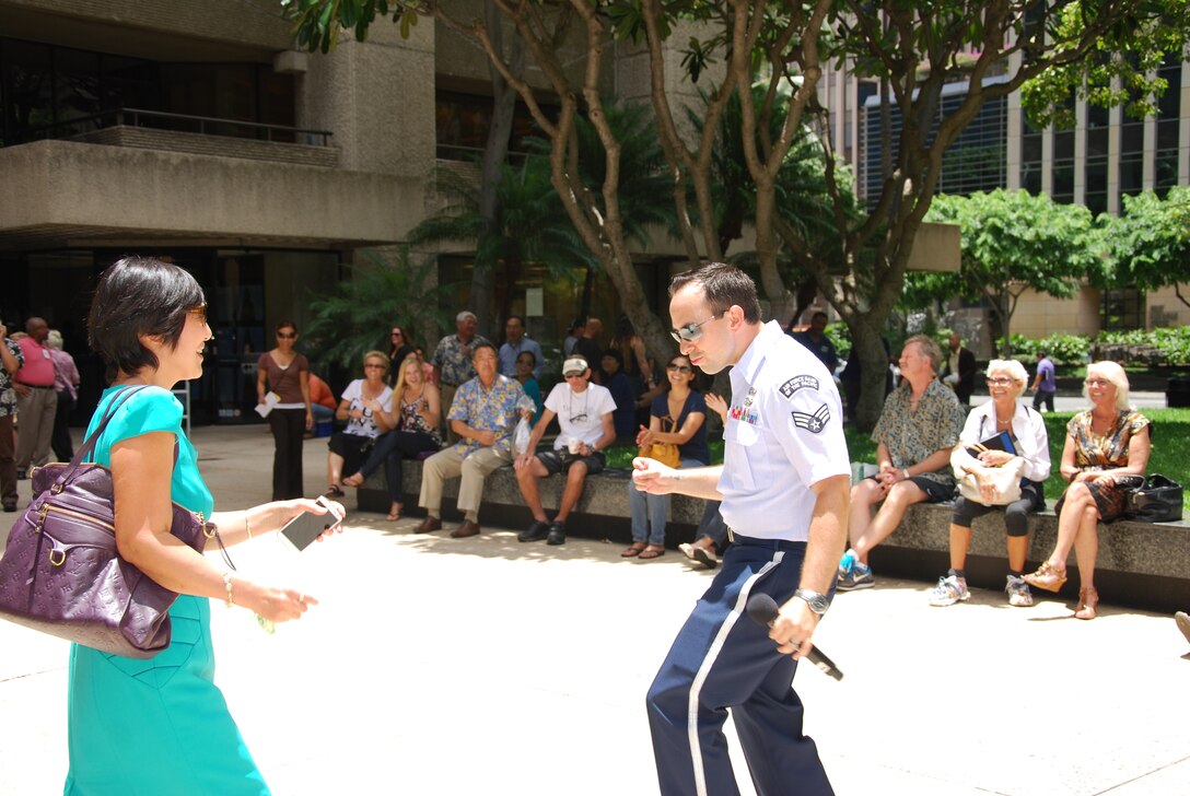 HONOLULU, Hawaii-- Senior Airman Devin Rivas Martin, Band of the Pacific-Hawaii vocalist, dances with a member of the audience during a Hana Hou! performance at Tamarind Park, August 7, 2013. The group performed a lunch-time concert for the thousands of people that work and live in the financial district of Honolulu. 

(US Air Force Photo/TSgt Stanley Johnson/ released)