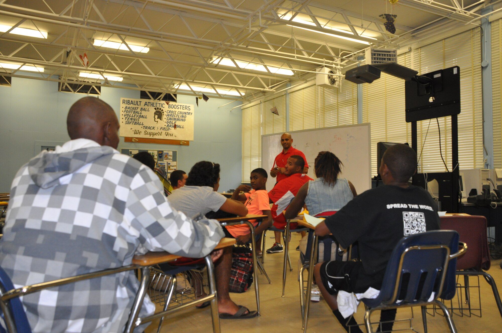 Major Brandon Acosta, 63rd Air Refueling Squadron KC-135 Stratotanker instructor pilot and volunteer director at the Aviation Career Education Academy, mentors students at the ACE Academy during a week long course in Jacksonville, Fla., July 22, 2013. The camp serves as a support network for underserved communities with a focus on middle and high school students, to provide insight and hands-on experience for students to learn the fundamentals of aerodynamics, various careers available in the aviation industry and create a career path for their future. (U.S. Air Force photo by Major Christine Stanaback/Released)