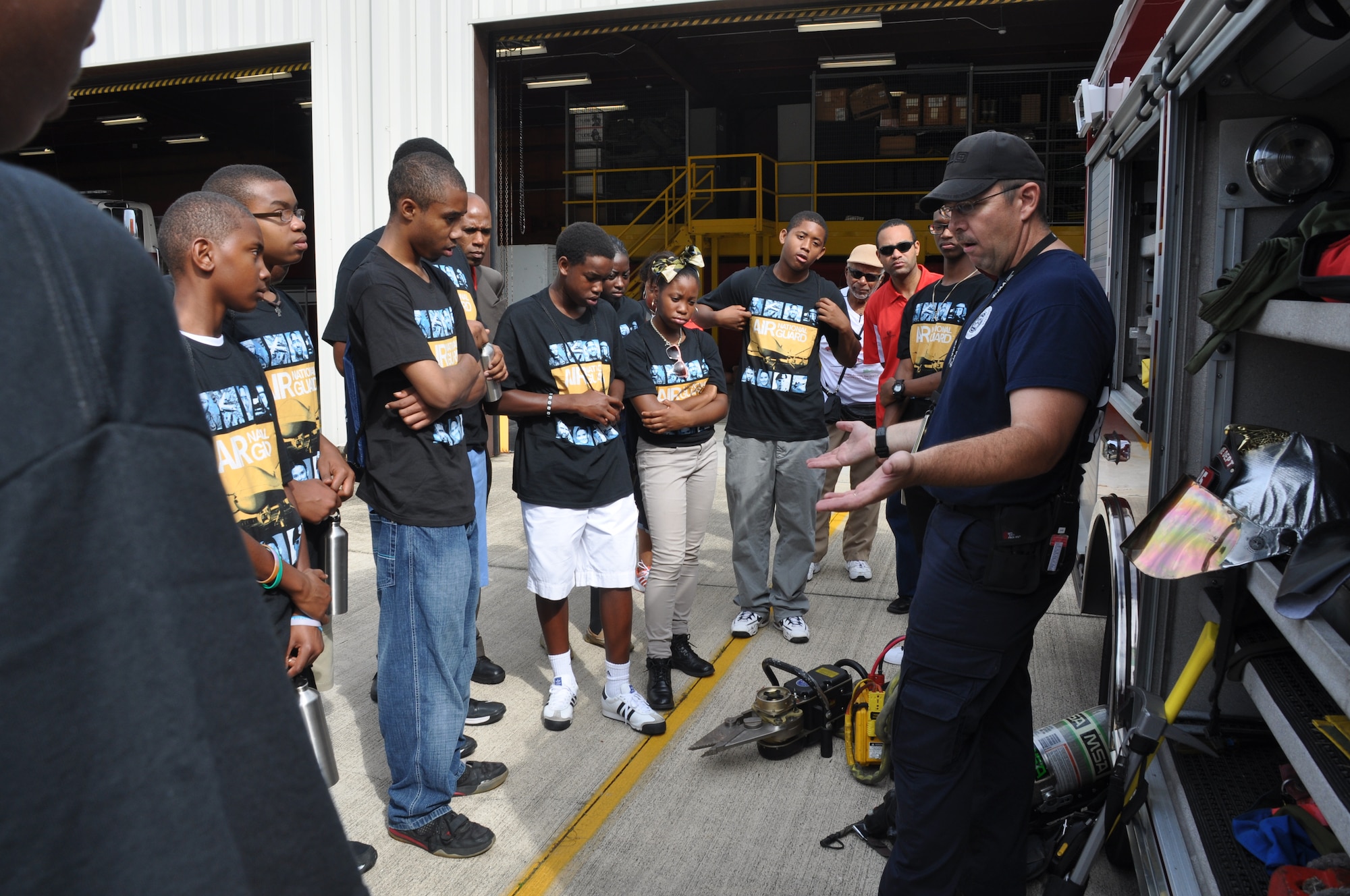 Staff Sgt. Scott Smith, 125th Fighter Wing assistant chief of fire prevention, discusses paths to becoming a fireman and displays some of the unique tools used for fire rescue with Aviation Career Education Academy attendees, at Jacksonville Air National Guard Base, Jacksonville, Fla., July 23, 2013. Members of the 927th Air Refueling Wing are volunteer instructors at the academy which teaches children about all aspects of the aviation career field. (U.S. Air Force photo by Major Christine Stanaback/Released)