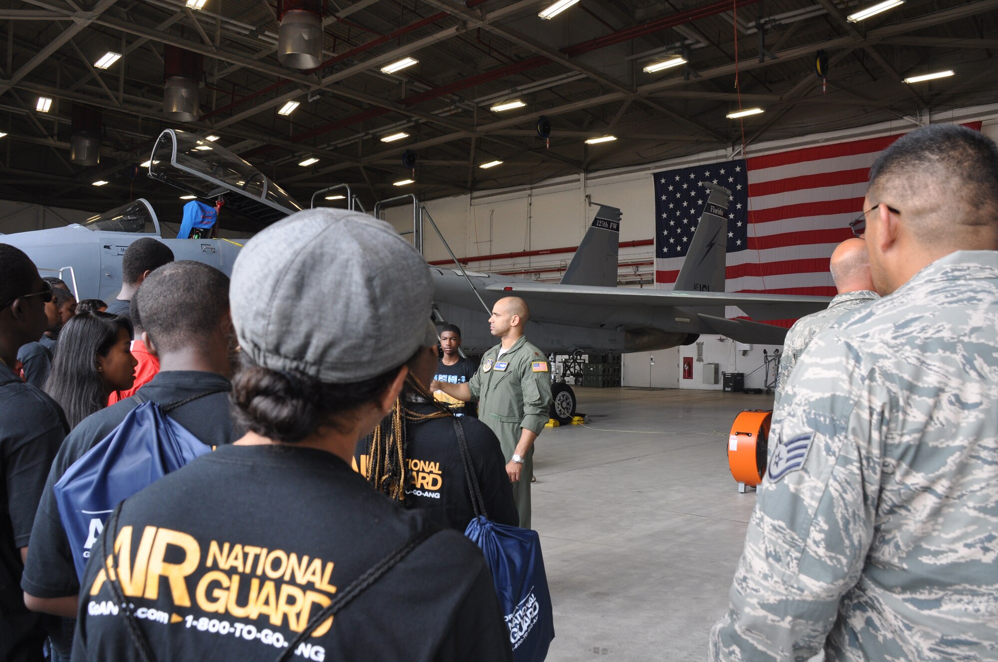 Major Brandon Acosta, 63rd Air Refueling Squadron KC-135 Stratotanker instructor pilot and volunteer director at the Aviation Career Education Academy, talks to ACE Academy students at Jacksonville Air National Guard Base, Jacksonville, Fla., July 25, 2013.  The students toured an F-15 hangar and learned about how teamwork is required to conduct aerial refueling missions between the 927th Air Refueling Wing and 125th Fighter Wing. (U.S. Air Force photo by Major Christine Stanaback/Released)