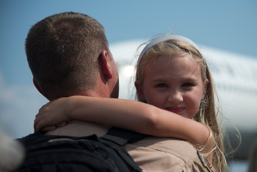 Ashley Groomes smiles as she hugs her father Lt. Col. Todd Groomes, 17th Airlift Squadron commander, during the 17th AS redeployment Sept. 4, 2013, at Joint Base Charleston - Air Base, S.C. More than 100 Airmen from the 17th AS returned home from a 60-day deployment to Southwest Asia. Flying the C-17 Globemaster III, crews flew and supported roughly 790 sorties, logged more than 1,860 combat flying hours and airlifted more than 19.5 million pounds of cargo. (U.S. Air Force photo/Tech. Sgt. Rasheen Douglas)