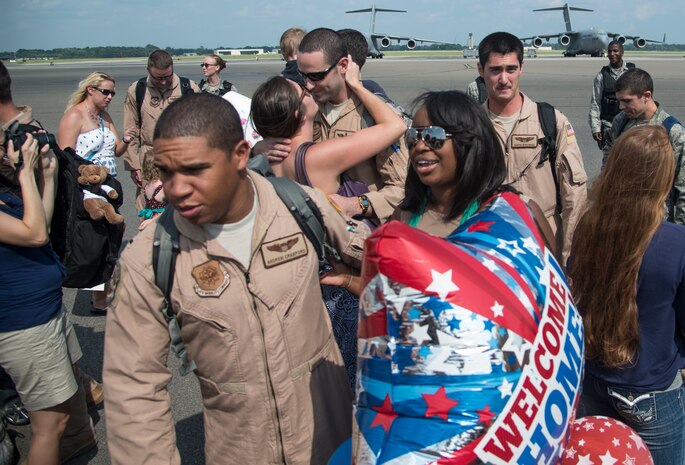 17th Airlift Squadron Airmen reunite with their families during the 17th AS redeployment Sept. 3, 2013, at Joint Base Charleston - Air Base, S.C. More than 100 Airmen from the 17th AS returned home from a deployment to Southwest Asia. Flying the C-17 Globemaster III, crews flew and supported roughly 790 sorties, logged more than 1,860 combat flying hours and airlifted more than 19.5 million pounds of cargo. (U.S. Air Force photo/Tech. Sgt. Rasheen Douglas)