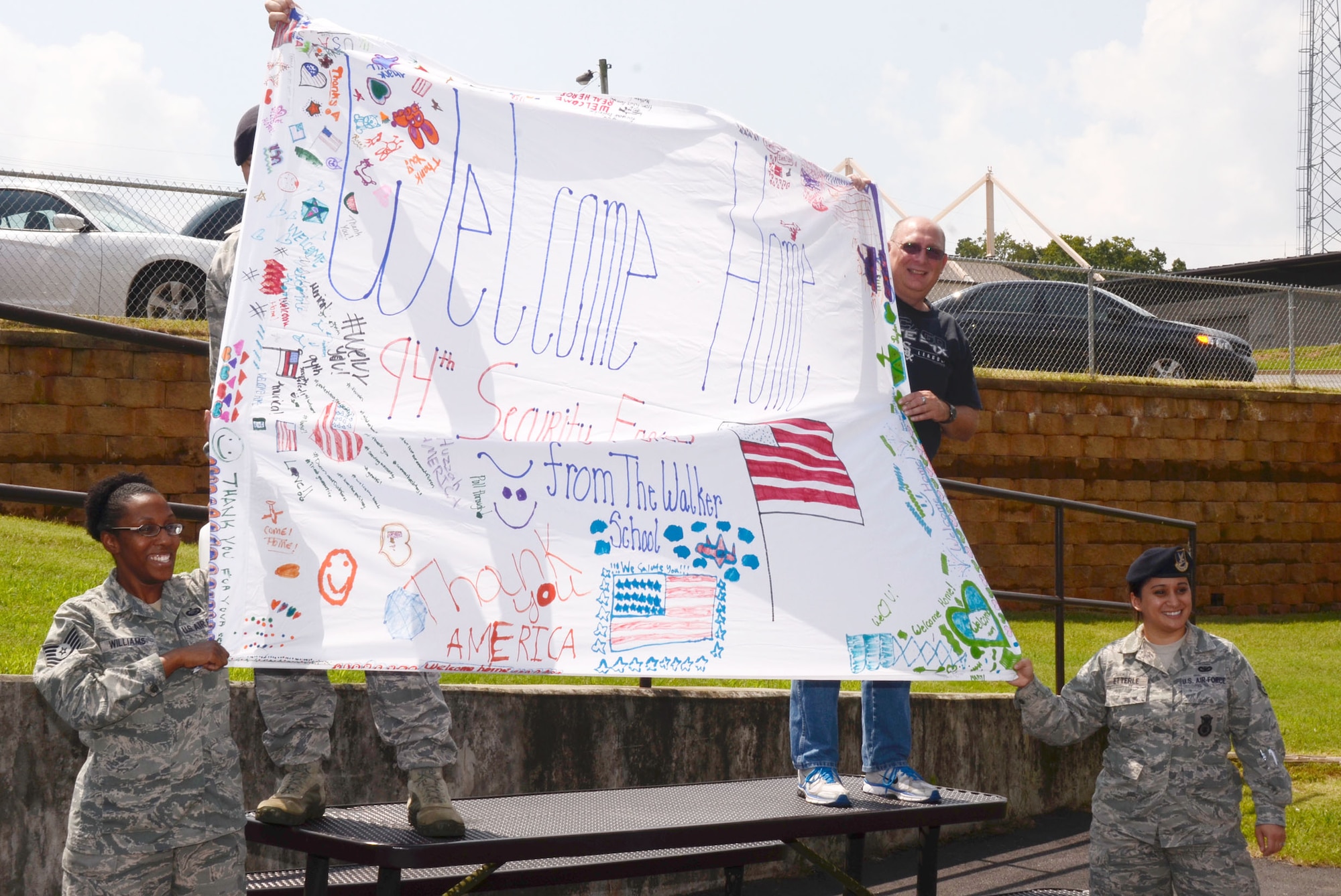 A welcome home banner created by students from The Walker Elementary School, Marietta, Ga., greeted members of the 94th Security Forces Squadron arriving back on Dobbins Air Reserve Base, Ga., from deployment to the Middle East Sep. 3. (U.S. Air Force photo/Don Peek)