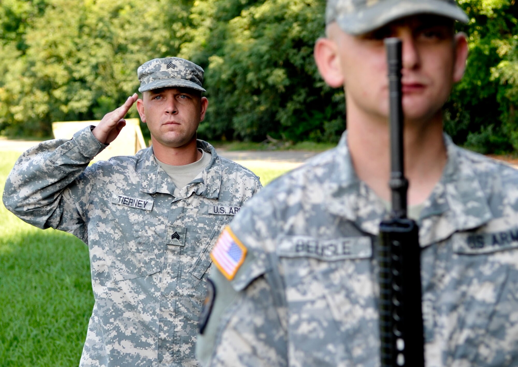(From front) U.S. Army Spc. Donald Belisle, Fort Eustis Honor Guard Rifle Team member, and Sgt. Eric Tierney, Fort Eustis Honor Guard Rifle Team noncommissioned officer in charge, present arms during daily practice at Fort Eustis, Va., Aug. 27, 2013. Soldiers serving on the honor guard serve on three-month rotations. (U.S. Air Force photo by Staff Sgt. Wesley Farnsworth/Released)
