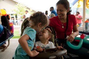 Alicia Pisculli, daughter of U.S. Air Force Tech. Sgt. Thomas Pisculli, 30th Intelligence Squadron imagery analysts, plays with her brother, Jacob, and mother, Kayte, during the Langley Air Force Base Back to School Celebration in Hampton, Va., Aug. 29, 2013. Families, like the Piscullis, celebrated the end of summer and the beginning of the school year with free food, music and various games and activities. (U.S. Air Force photo by Staff Sgt. Stephanie Rubi/Released)