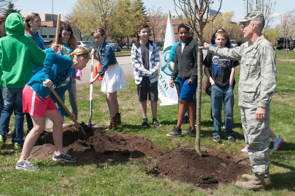 HANSCOM AIR FORCE BASE, Mass -- Col. Lester A. Weilacher, 66th Air Base Group commander, as well as Hanscom Middle School students help plant a tree along Eglin Street near the clinic as part of Arbor Day activities last spring. The nonprofit Arbor Day Foundation has recognized Hanscom’s commitment to urban forestry by naming the base a Tree City USA community for the 26th consecutive year. (U.S. Air Force photo by Mark Herlihy)