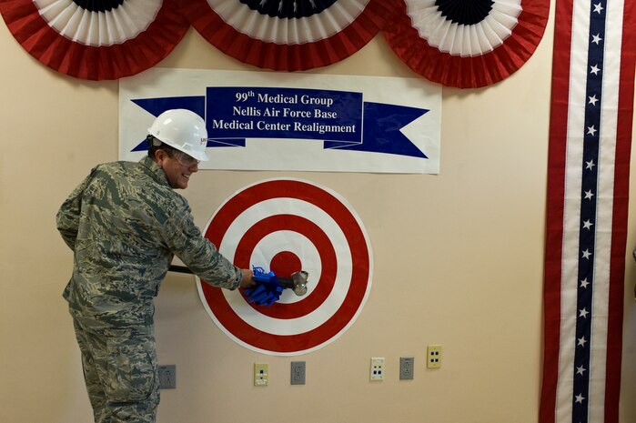 Col. (Dr.) Guillermo Tellez, 99th Medical Group commander, swings a sledge hammer during a wall breaking ceremony to start a renovation project worth $72 million at the Mike O' Callaghan Federal Medical Center Aug. 28, 2013, at Nellis Air Force Base, Nev. Women's health, labor and delivery, intensive care unit and the chapel will be the first areas to see design improvements. Additionally, a state of the art hybrid operating room suite is being added along with an enhanced medical surgical unit, sleep lab and pharmacy. (U.S. Air Force photo by Airman 1st Class Christopher Tam)