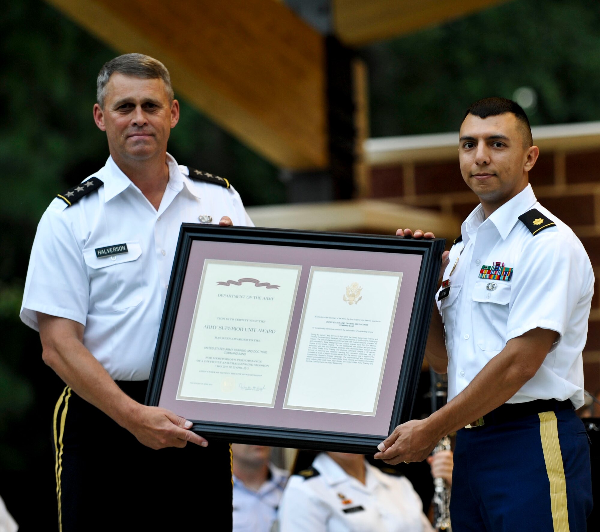 (From left) U.S. Army Lt. Gen. David Halverson, U.S. Army Training and Doctrine Command deputy commanding general, presents Maj. Leonel Pena, TRADOC Band commander, with the band’s second Army Superior Unit Award during the “Music Under the Stars” season finale concert in Magnolia Park at Fort Eustis, Va., Aug. 29, 2013. The band received the award for “outstanding meritorious performance of a difficult and challenging mission carried out under extraordinary circumstances," from May 1, 2011 through April 30, 2012. (U.S. Air Force photo by Staff Sgt. Wesley Farnsworth/Released)