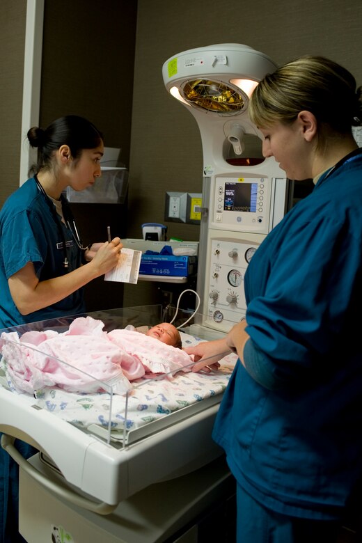 U.S. Air Force Staff Sgt. Jaqueline Petrakis, 633rd Inpatient Squadron medical technician, and 1st Lt. Lauren Casey, 633rd IPTS registered nurse, monitor a newborn baby at Langley Air Force Base, Va., Aug. 22, 2013. Technicians and nurses work closely with doctors through the labor and delivery process by preparing necessary equipment for use during delivery and working with new parents after the baby is born. (U.S. Air Force photo by Staff Sgt. Stephanie Rubi/Released) 