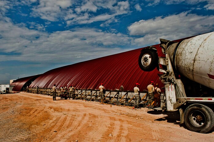 Structures Airmen from the 820th RED HORSE finish smoothing out fresh concrete on the side of a K-Span building for the 58th Rescue Squadron Aug. 29, 2013, at Nellis Air Force Base, Nev. RED HORSE units possesses cradle-to-grave design-build capability, to include site surveying, design, planning, procurement and full construction. Typical RED HORSE projects include the construction of buildings and the pavement of roads. (U.S. Air Force photo by Senior Airman Daniel Hughes)