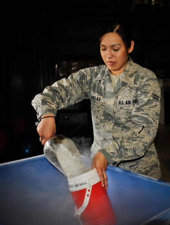 Airman 1st Class Jacqueline Douglas, 87th AMDS Public Health Flight technician, pours dry ice into a canister Aug. 19, 2013, at Joint Base McGuire-Dix-Lakehurst, N.J. The dry ice will be used in a New Jersey Light Trap because female mosquitoes are  attracted to carbon dioxide. 



 