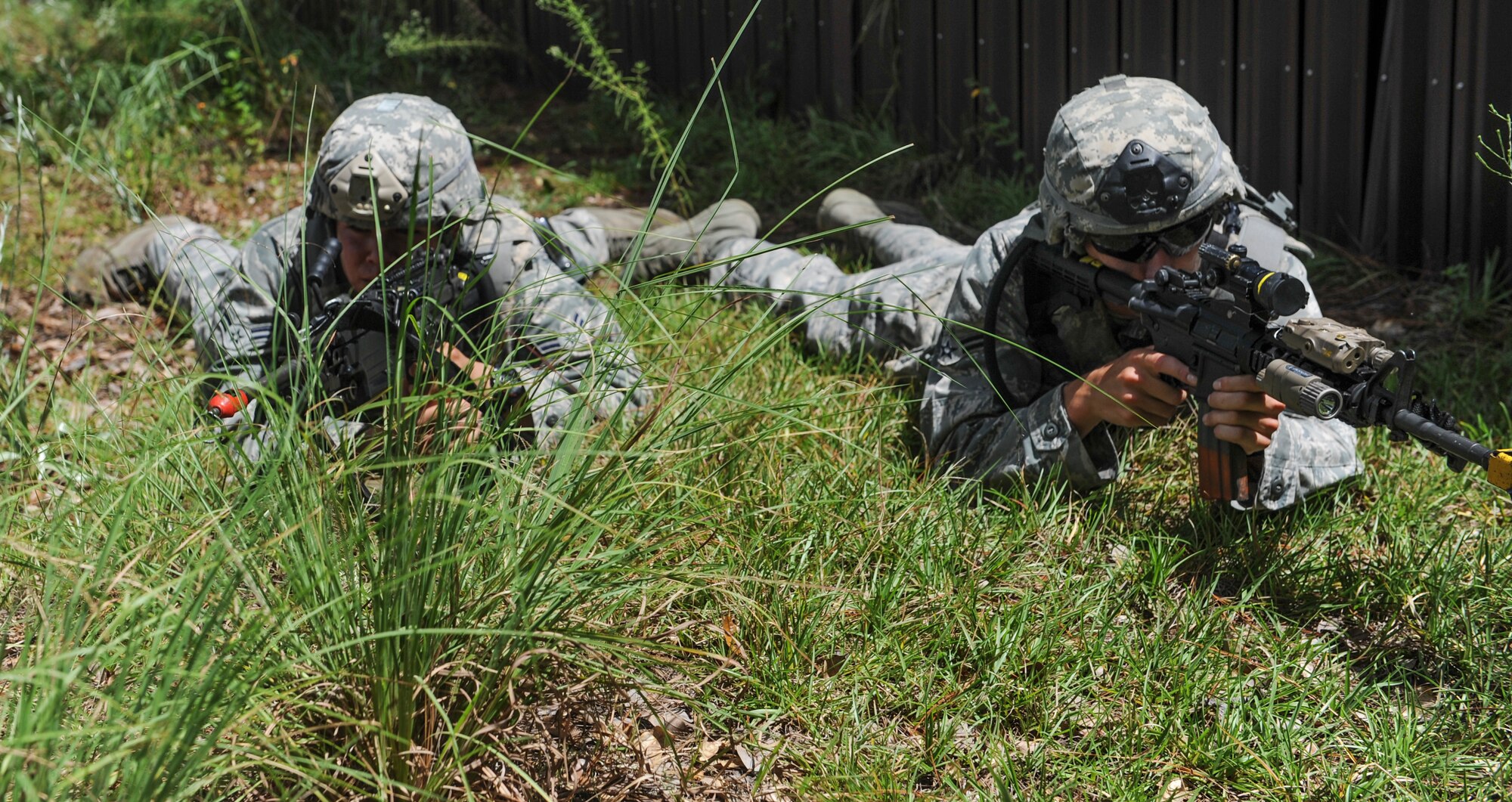 U.S.  Air Force Airmen 1st Class Alexis Romero (left) and Chase Elliot (right), 824th Base Defense Squadron fireteam members, watch for enemy attacks during an exercise at Moody Air Force Base, Ga., Aug. 23, 2013. Romero and Chase were part of a ground operation team during the first mission. (U.S. Air Force photo by Airman Alexis Grotz/Released)