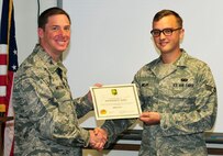 Col. Alexis Mezynski, 5th Bomb Wing commander, presents the OWN IT award to Senior Airman Jeremy Melby, 5th Contracting Squadron here, Aug. 26. Melby is the Contract Administrator for 35 Blanket Purchase Agreements valued at $47,465,000.00, which provided base-wide, critical support functions from tactical and cold-weather gear purchases, base and missile site snow removal, rudimentary construction projects, to carpet removal and installation.  During Melby’s recent scrub of eight end-of-year tactical and cold-weather gear purchase requests worth $1,066,013.90, he identified an innovative way to meet federal competition mandates while making purchases over $250,000 in less than three days, effectively doubling Minot Air Force Base’s cold weather gear purchasing power. He initiated this by soliciting and creating a new tactical and cold-weather gear blanket purchase agreement with a local vendor, while simultaneously strengthening the base’s ties with the local community. His negotiation skills enabled the 5th CONS to quickly and legally facilitate its biggest one time tactical and cold-weather gear purchase for the 91st Missile Security Forces Squadron while securing $62,987.29 in pricing discounts; a six percent total cost savings to the federal government and Minot AFB. Without Melby’s attention to detail and mission dedication, Minot AFB’s Security Forces, Aircraft Maintenance and Fire Protection personnel would be ill-equipped to accomplish their missions in ensuring "safe, secure, reliable” nuclear deterrence operations in direct support of the Commander in Chief and Combatant Commanders. (U.S. Air Force photo/Airman 1st Class Kristoffer Kaubisch)