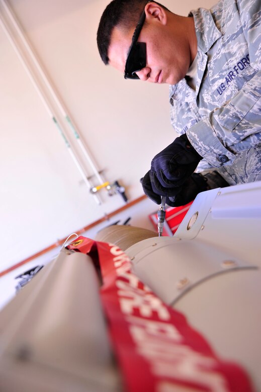 CREECH AIR FORCE BASE, Nev. -- A munitions Airman tightens bolts on a GBU-12 during a bomb build June 19, 2013, in preparation for the 432nd Wing Hunt competition. The bombs were used to further the realism and intensity of the competition, as they were used for live munitions loading on the MQ-9 Reaper. The competition takes place June 23-28 between multiple remotely piloted aircraft squadrons, offering an opportunity for training and demonstration of skill. During the competition, RPA squadron teams were required to formulate a mission plan, evaluate a threat and develop a strategy to execute the mission effectively. (U.S. Air Force photo illustration by Senior Airman A.K./Released)