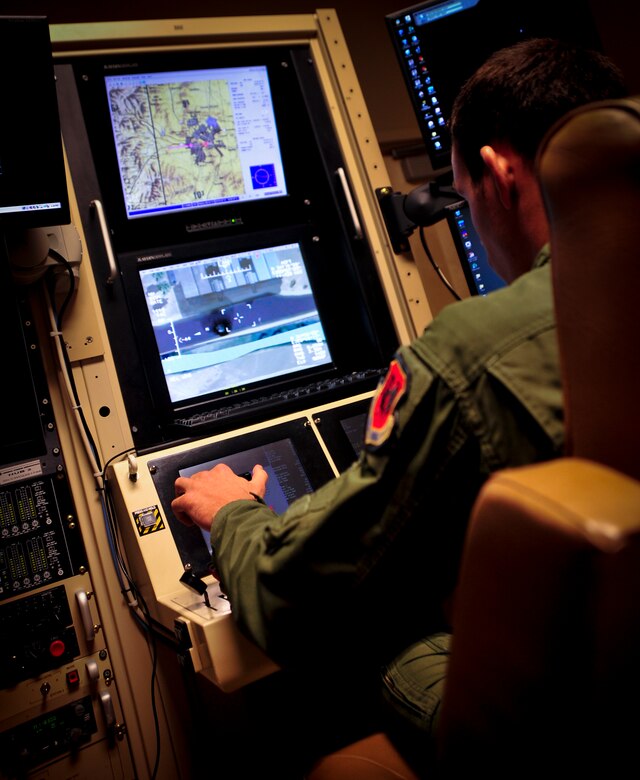 CREECH AIR FORCE BASE, Nev. – A sensor operator from the 432nd Operations Support Squadron, scans his controls during a simulated training mission in a MQ-1 Predator, over the Nevada Test Range, Nev. Oct. 26, 2013. The basic crew for the Predator is a rated pilot to control the aircraft and command the mission, and an enlisted aircrew member to operate sensors and weapons as well as a mission coordinator, when required. The crew employs the aircraft from inside the ground control station via a line-of-sight data link or a satellite data link for beyond line-of-sight operations. (U.S. Air Force photo by Staff Sgt. A.D./RELEASED)

