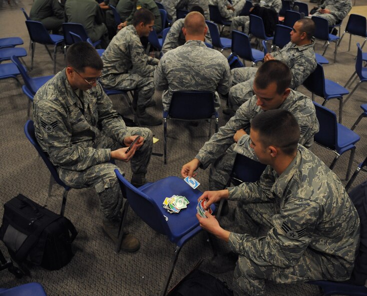 Airmen from the 2nd Munitions Squadron play a card game as they wait for their flight to Andersen Air Force Base, Guam, on Barksdale Air Force Base, La., Aug. 30, 2013. Several units from the 2nd Bomb Wing including, the 20th Aircraft Maintenance Unit, 2nd Operations Support Squadron and 2nd Munitions Squadron, deployed to Guam in support of the Continuous Bomber Presence mission. (U.S. Air Force photo/Senior Airman Benjamin Gonsier) 